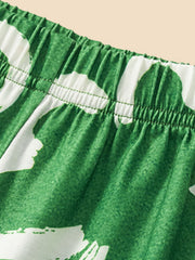 Green toddler pants with white clover print and elastic waistband.