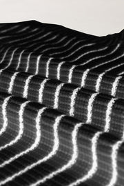 Black and ivory striped knit polo vest with textured fabric detail.
