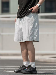 Men's light gray textured drawstring shorts with pockets.