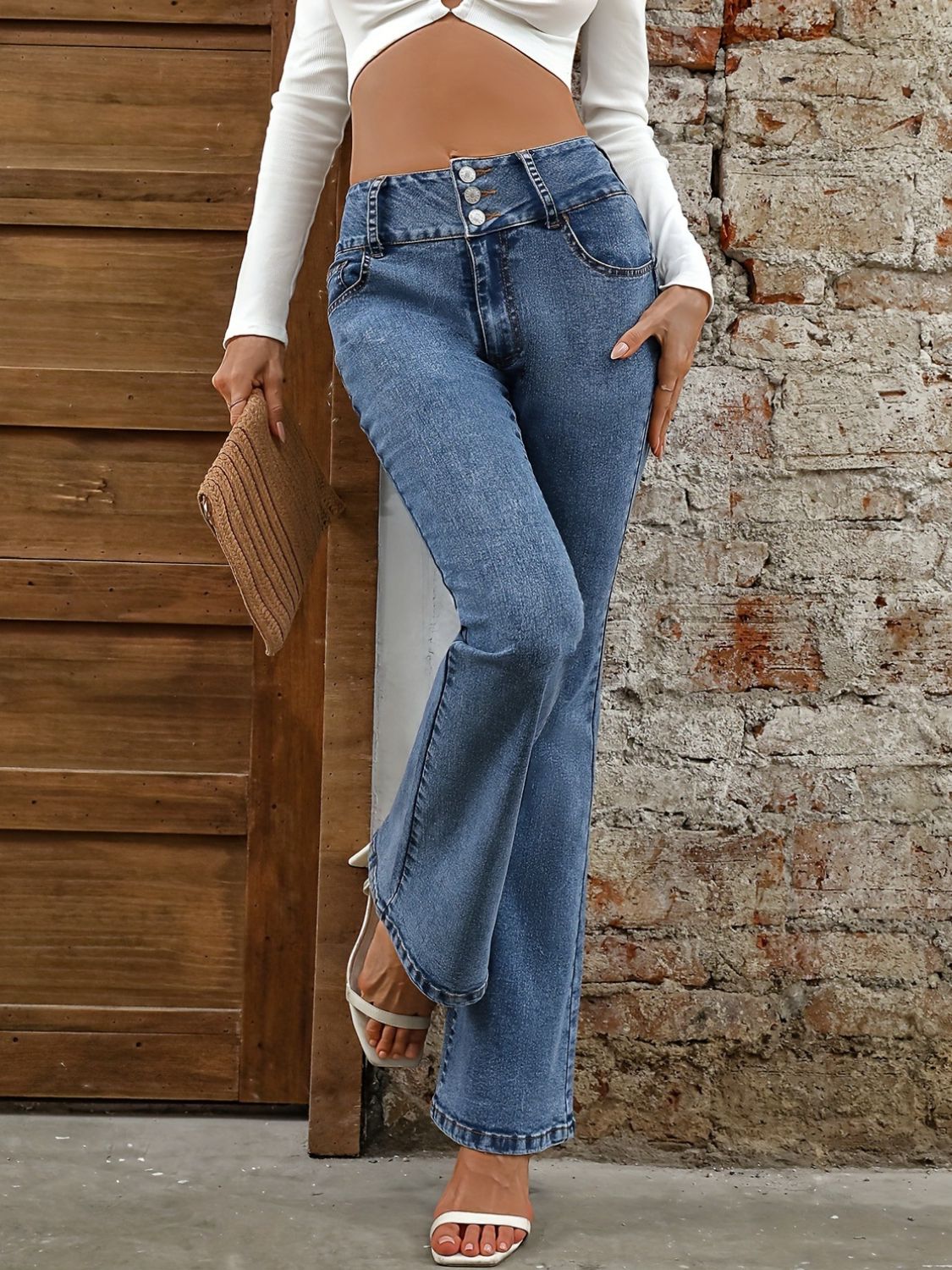 Medium wash cotton bootcut jeans with a high waist and button fly detail