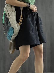 Black chino shorts with elastic waist and pockets, styled with a crossbody bag.