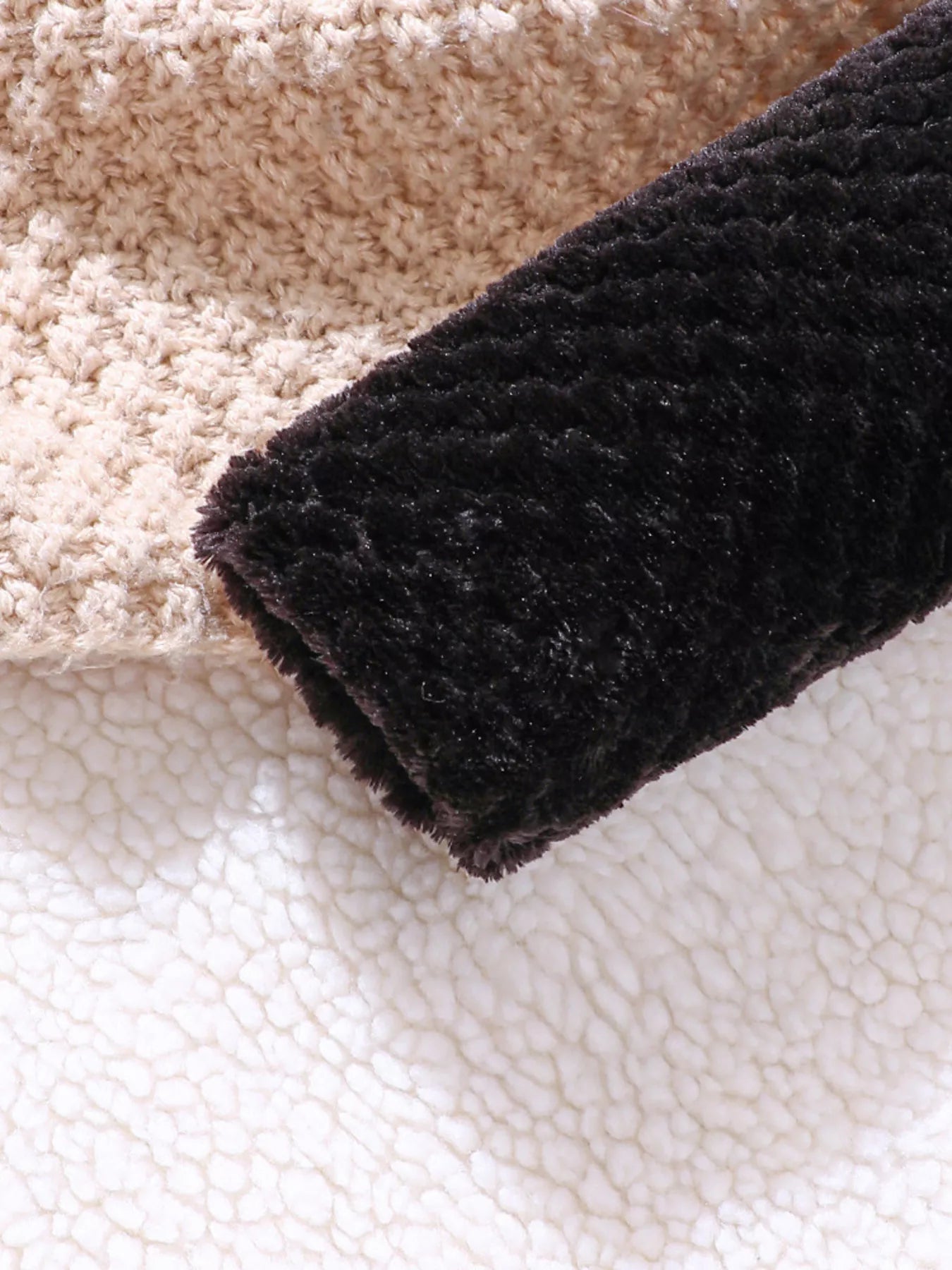 Children's fuzzy black cardigan sleeve detail with beige knit and sherpa lining.