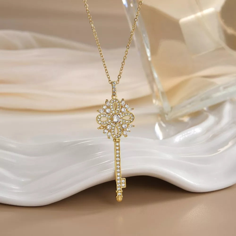 Gold-plated key pendant necklace with clear crystals and delicate chain.