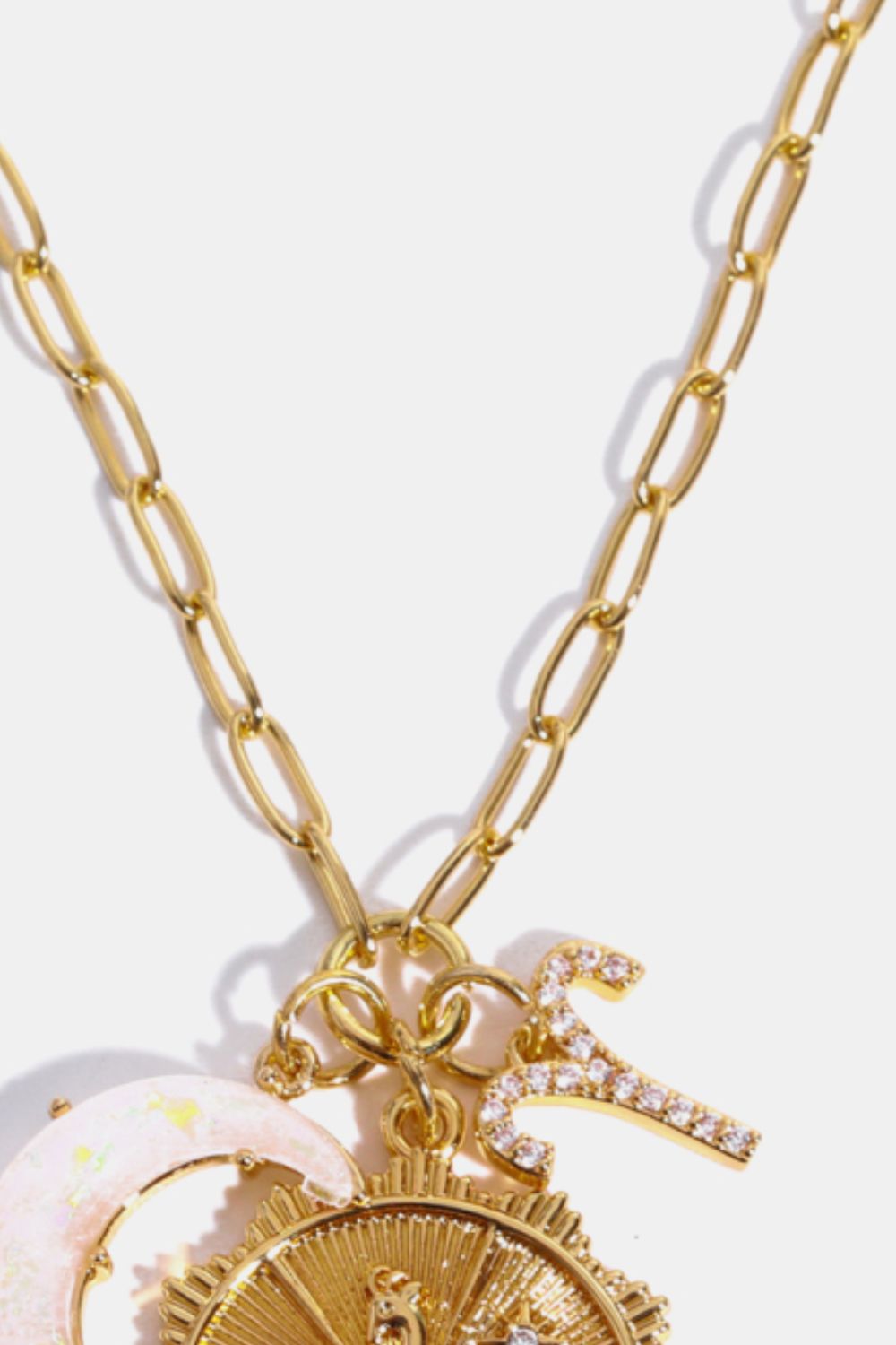 Gold celestial pendant necklace with zodiac symbols and moon charm.