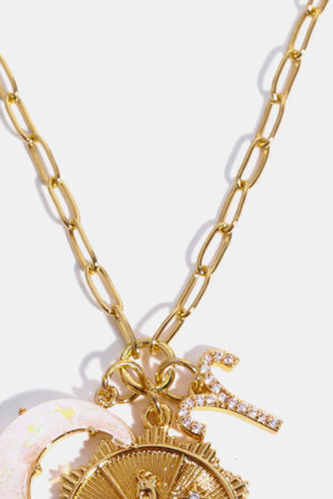 Gold celestial pendant necklace with zodiac symbols and moon charm.