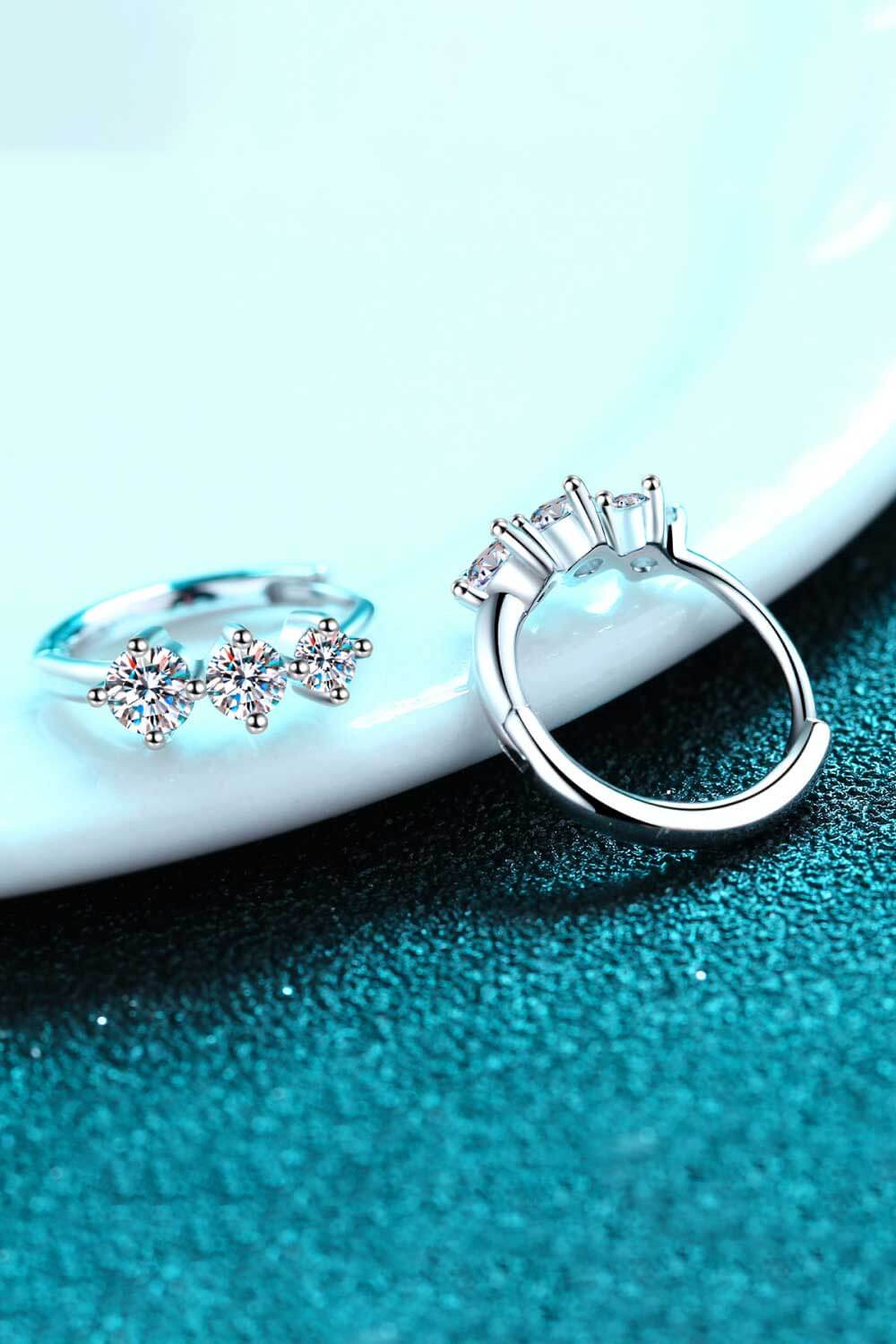 Silver triple stone cluster huggie earrings with sparkling cubic zirconia.