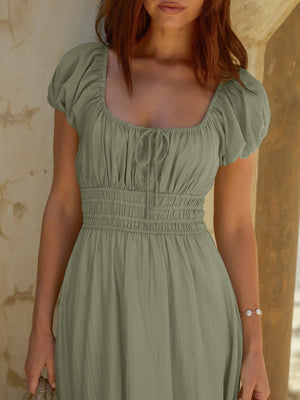 Sage green smocked waist maxi dress with square neckline and puff sleeves.