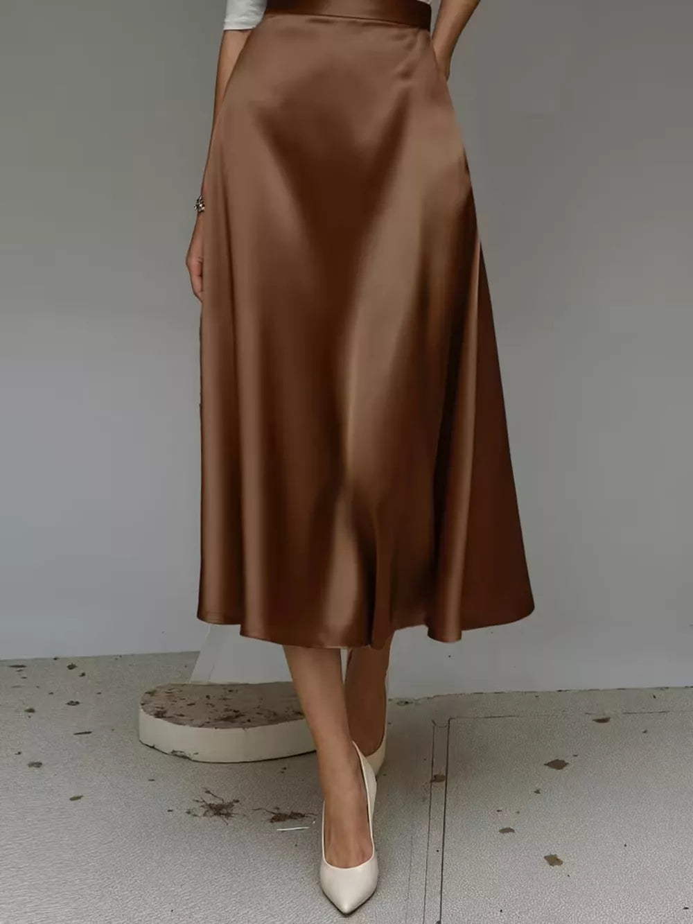 Elegant A-line satin skirt in dark brown with pockets, midi length.
