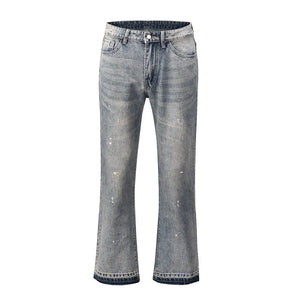 Distressed wash bootcut jeans with raw hem and paint splatter details.