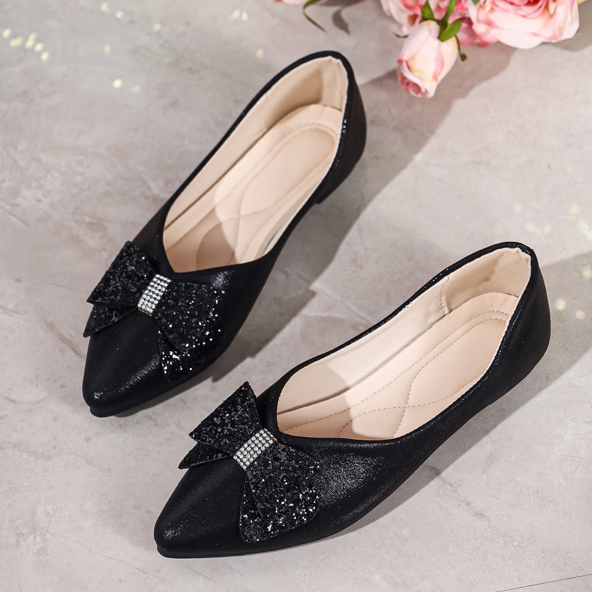 Black pointed toe flats with dazzling sequin bows and rhinestone detail.