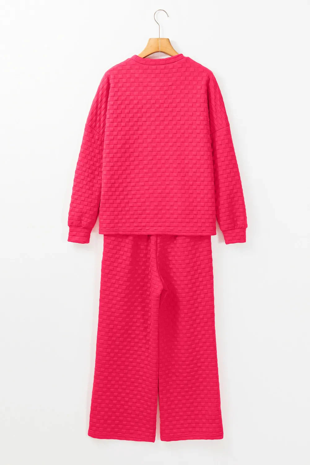 Textured weave lounge set in strawberry pink, featuring a crewneck sweatshirt and wide-leg pants.
