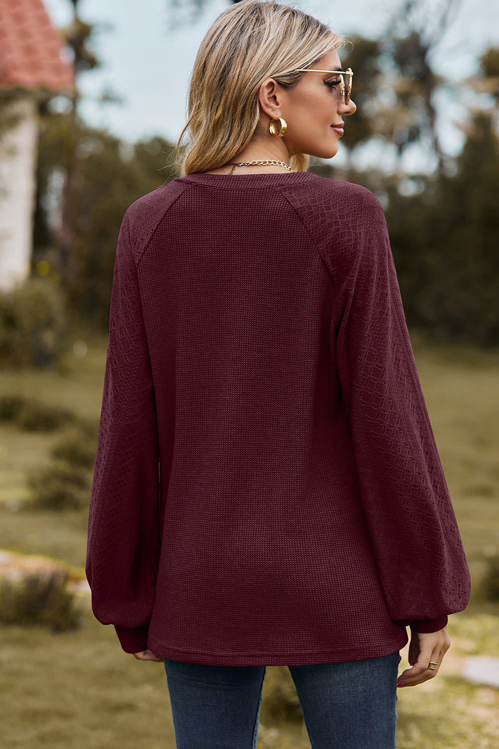 Burgundy waffle knit raglan top with textured sleeves and a V-neck.