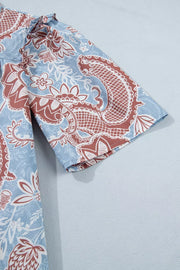 Cotton button-up shirt with blue floral paisley print and scalloped trim detail.