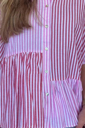 Tiered stripe ruffle sleeve blouse in pink with button front and short sleeves.