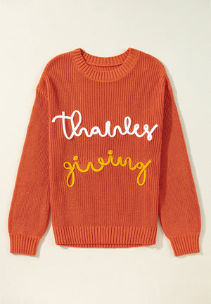 Orange knit sweater with white and yellow "thanks giving" text detail