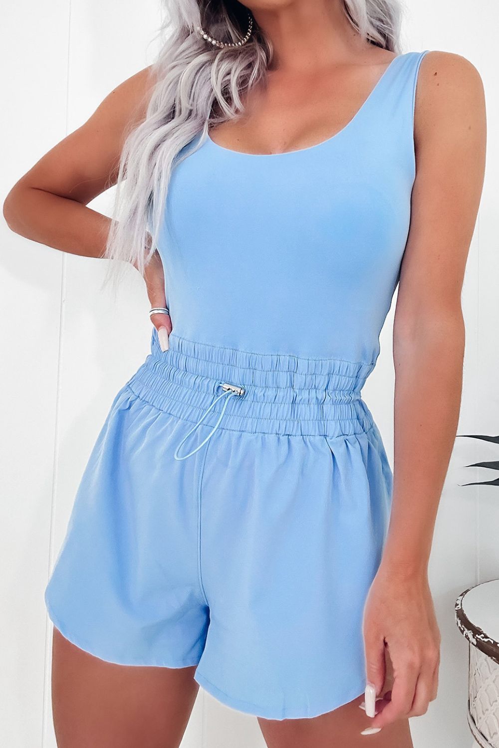 Light blue gathered waist tank romper with drawstring shorts and scoop neck.