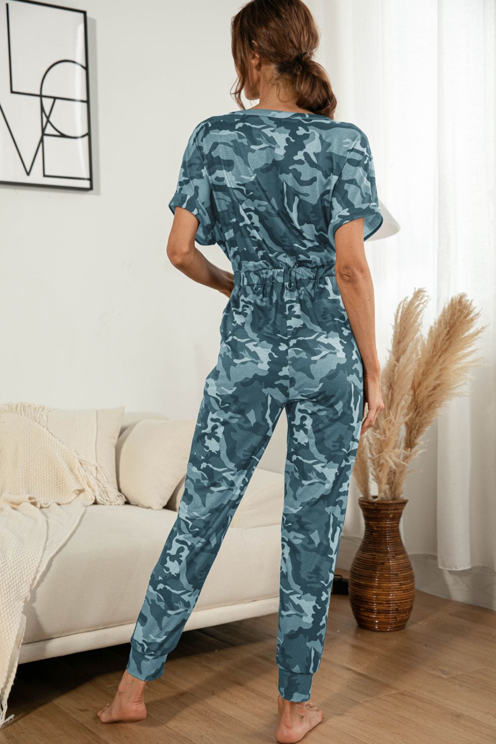 Sky blue camouflage print short sleeve surplice waist jumpsuit with elastic waistband.