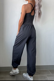 Dark gray cutout bodice gathered-leg jumpsuit with crisscross back detail and elastic cuffs.