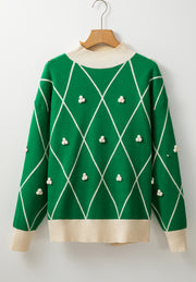 Dark green argyle knit sweater with mock neck and pom-pom embellishments.