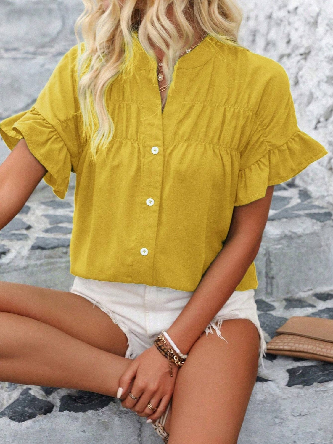 Yellow gathered yoke blouse with ruffle sleeves and button front.