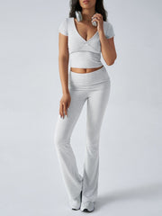 Light gray loungewear set with ruched waistband flared pants and a v-neck cropped top.