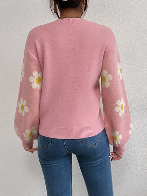 Pink knit sweater with puff sleeves and all-over daisy print.