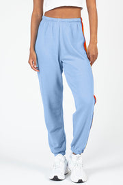 Light blue track pants with rainbow stripe detail down the side.