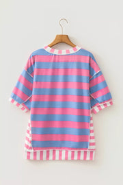 Oversized maternity shirt with pink and blue stripes, patchwork details, and white striped trim.
