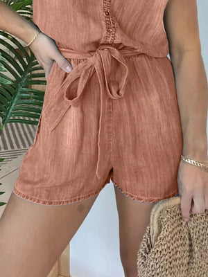 Belted tie-waist romper in burnt coral with button-down detail and cuffed hem shorts.