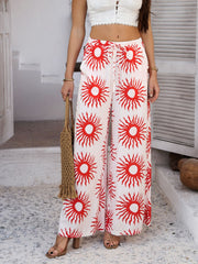 Wide-leg trousers in white with a red sun print and drawstring waist.