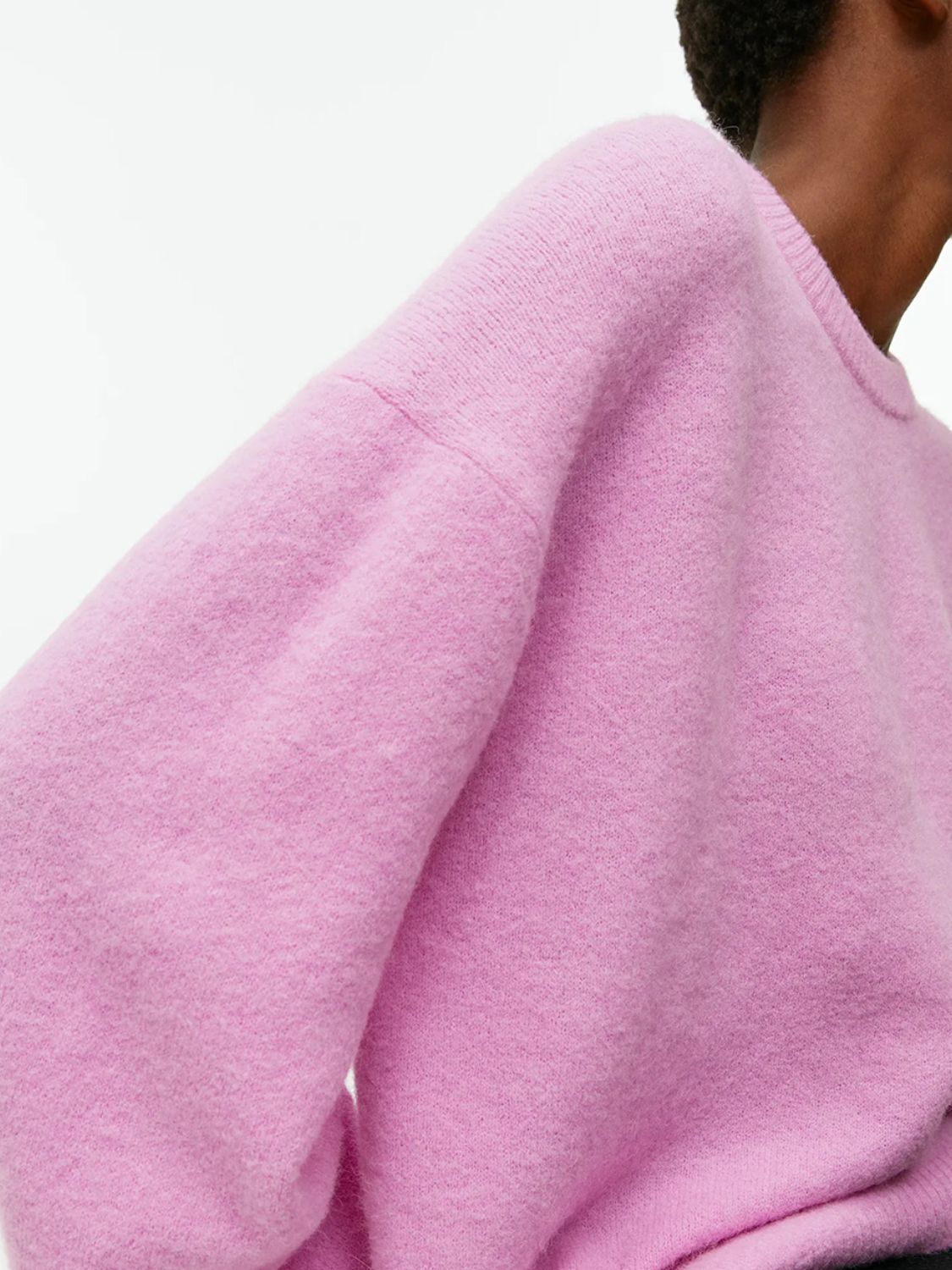Pink oversized brushed knit crewneck sweater with crew neckline and long sleeves.