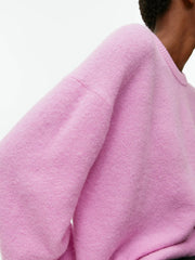 Pink oversized brushed knit crewneck sweater with crew neckline and long sleeves.