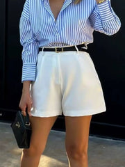 White high-waisted shorts with pleats and a black belt