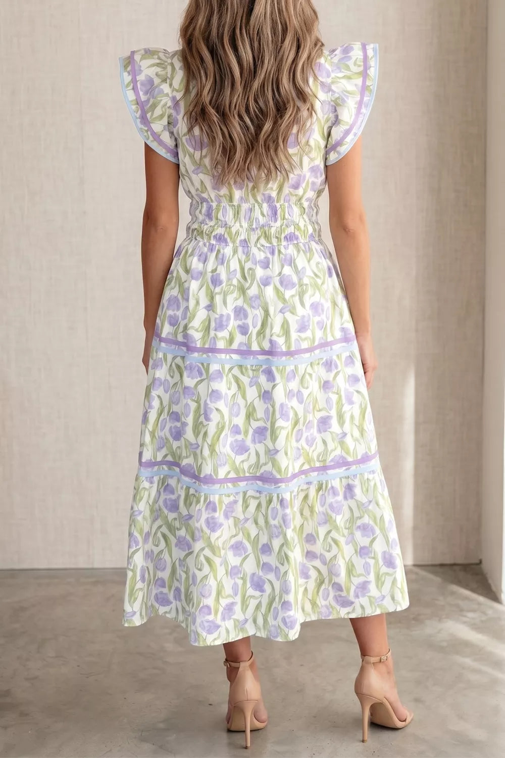 Lavender tulip print midi dress with ruffled sleeves, smocked waist, and tiered skirt with ribbon trim.