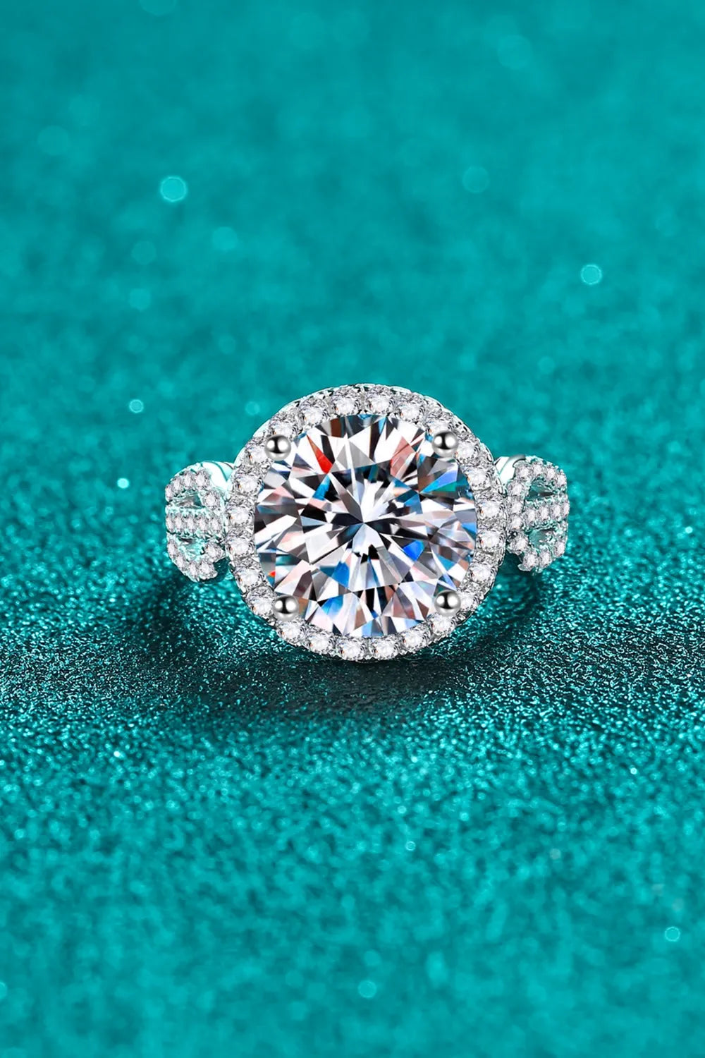 Silver halo moissanite ring with sculpted band and clear round center stone.