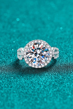 Silver halo moissanite ring with sculpted band and clear round center stone.