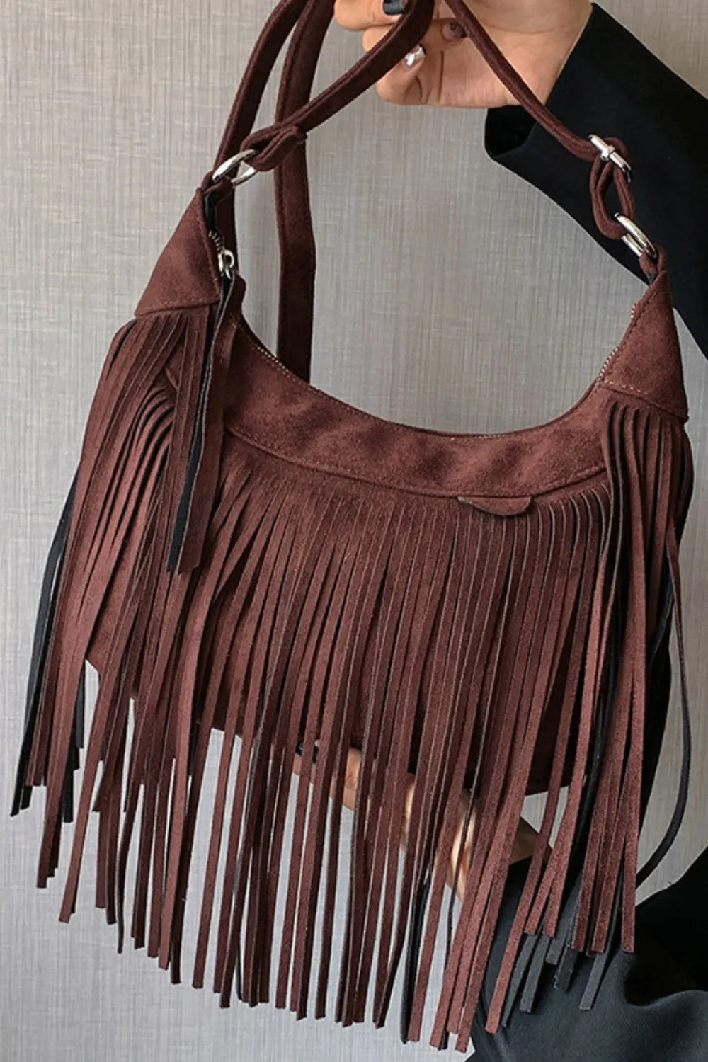Dark brown suede crescent crossbody bag with long fringe details.
