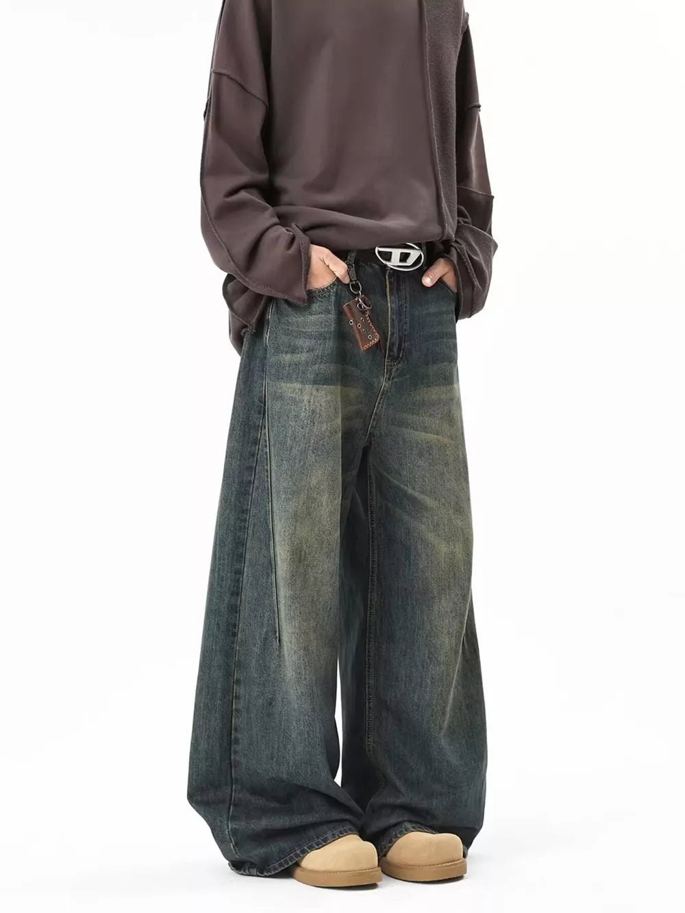 Men's vintage wash oversized blue cotton jeans with a belted waist and baggy fit.