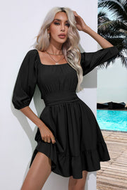 Black mini dress with square neckline, puff sleeves, belted waist, and ruffled hem.