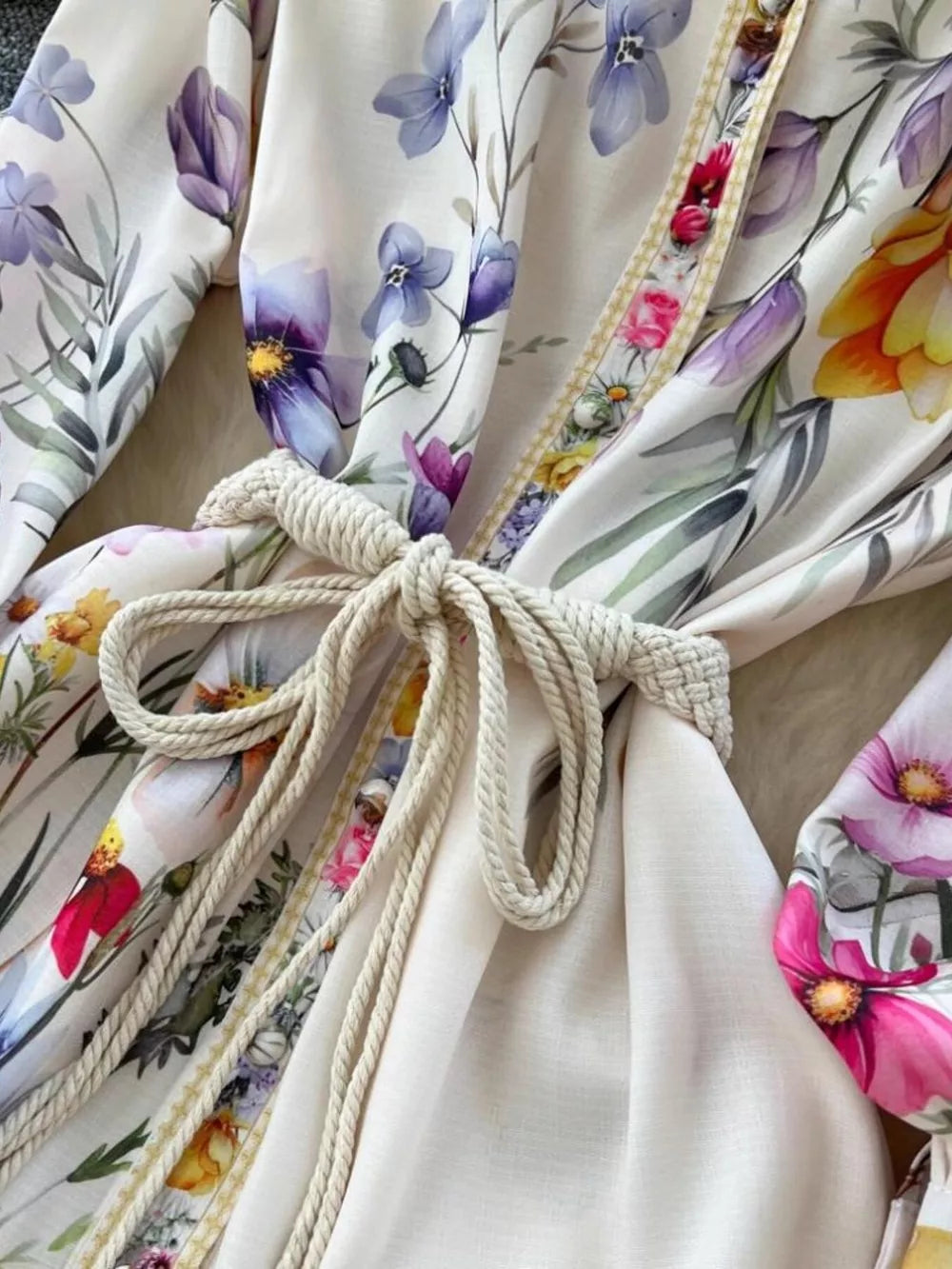 Vibrant floral midi dress with lantern sleeves, rope tie, and brocade trim.