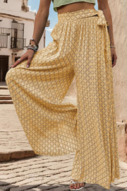 Yellow geometric print wide-leg palazzo trousers with a tie waist detail.