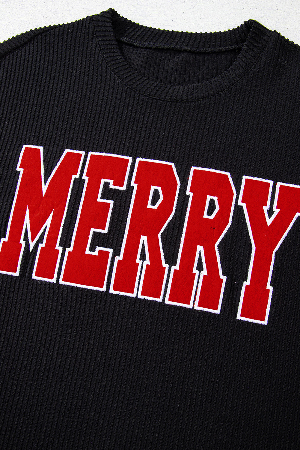 Black ribbed loungewear top with red "Merry" applique detail
