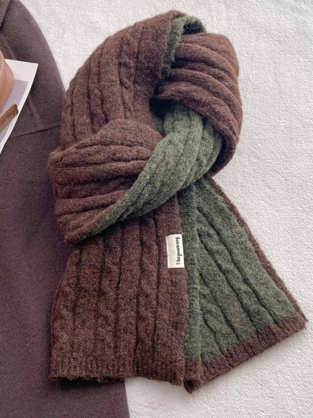 Textured two-tone wool blend scarf in brown and green with cable knit detail.