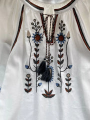 White tie neck blouse with colorful floral embroidery and tassels