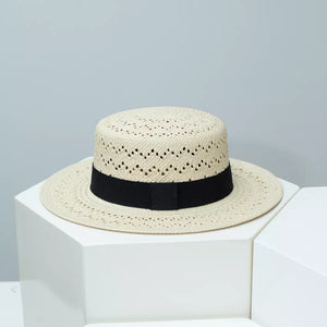 Classic woven straw boater hat in off-white with black ribbon band and eyelet detail