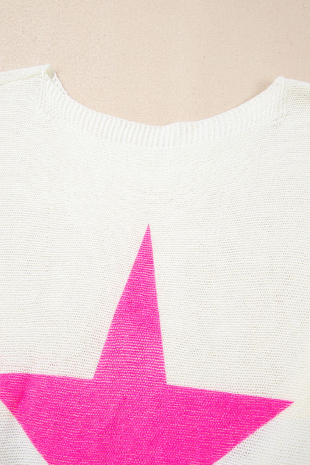White acrylic knit sweater with a bold neon pink star graphic and crew neck.