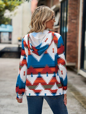 Aztec print zip-up hooded jacket with blue, white, orange and black geometric pattern.