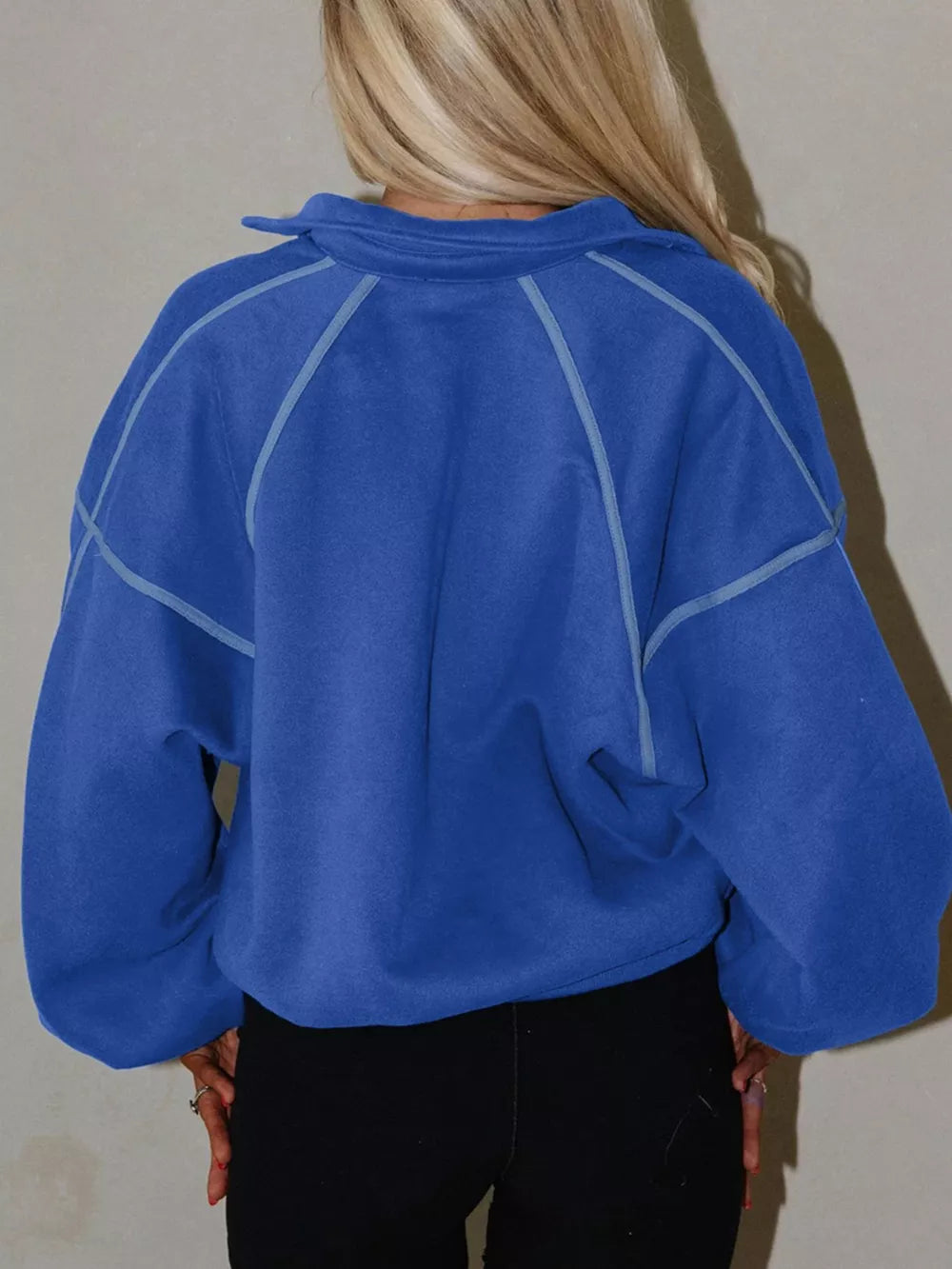 Blue cotton sweatshirt with snap collar and contrast stitching, relaxed fit.