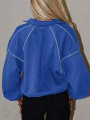 Blue cotton sweatshirt with snap collar and contrast stitching, relaxed fit.