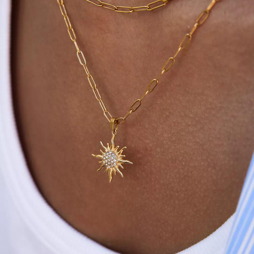 18k gold layered necklace with a sun pendant featuring crystal details.